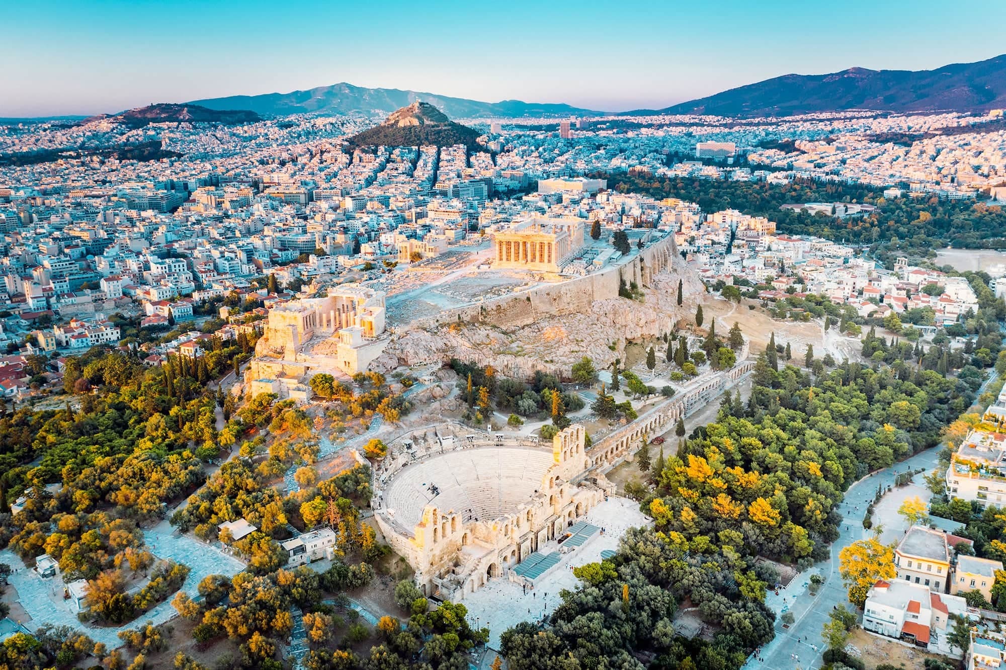 Aerial view of the Acropolis, the Odeon of Herodes Atticus and the densely populated cityscape of Athens, Greece, at golden hour